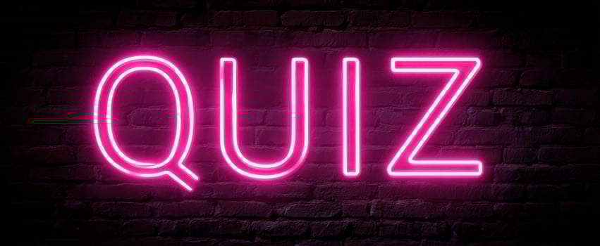 The Neon Quiz Sign against a Dark Brick Background. photo