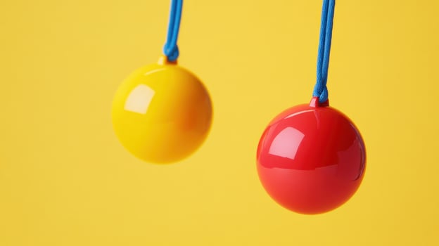 Two colorful balls hanging by strings photo