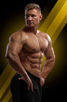 Handsome athletic man with naked torso demonstrates perfect abs photo