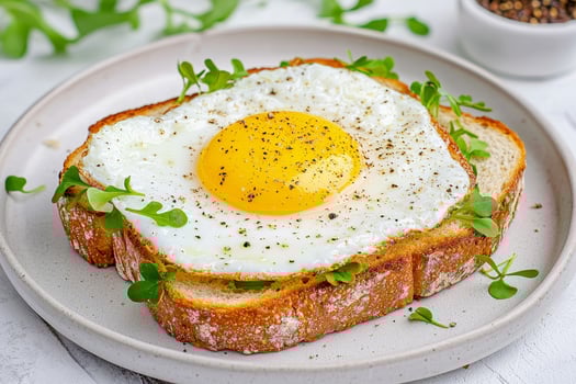 Fried egg on toast garnished with microgreens on a plate. photo