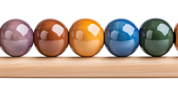 Colorful ceramic spheres balancing on wooden stick on white background photo