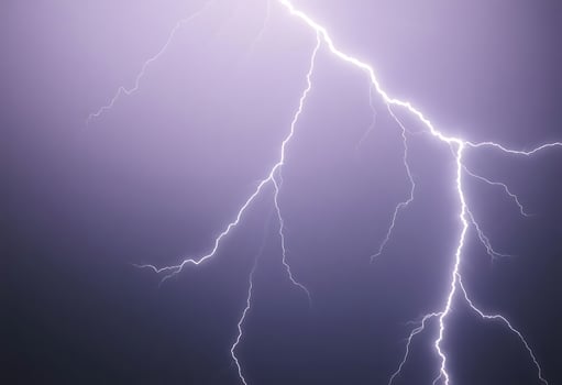 lightning bolt striking across a purple sky photo