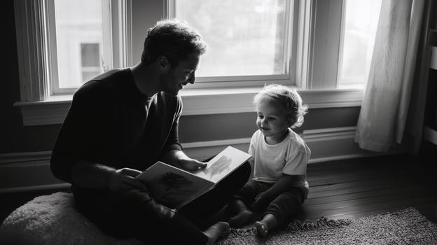 Father shares a story with toddler during cozy afternoon indoors in natural light photo