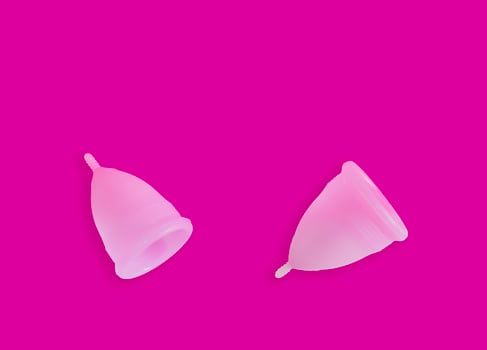 Pink menstrual cups isolated on pink background. Feminine hygiene photo