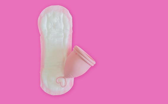 A silicone menstrual cup on the sanitary pad isolate on pink background with copy space. photo