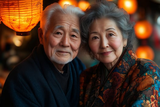 an elderly couple sitting together at an Obon celebration, surrounded by glowing lanterns and vibrant festival decorations photo