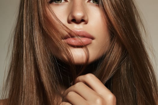 portrait of a young woman with long, flowing brown hair. Her radiant skin and delicate features exude natural beauty and elegance. photo