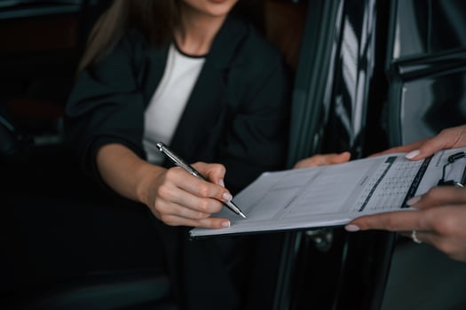 Process of buying new car, woman,, is, signing documents while sitting in a new automobile photo