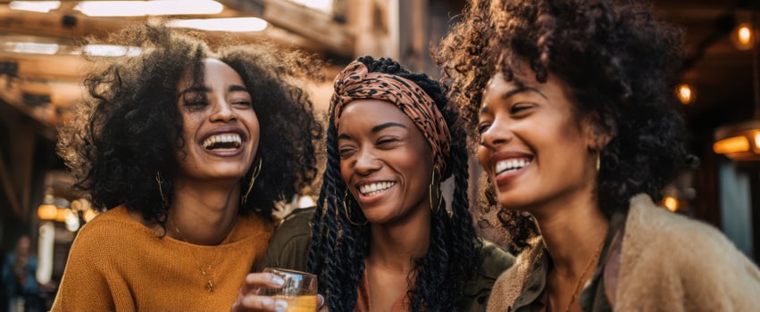 The women laughing together enjoying drinks in a vibrant social setting. photo