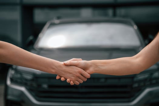 Side close ,up view of handshake of two women against car photo