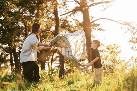 Preparing for, picnic, with ,blanket... Mother and son are in the forest together photo