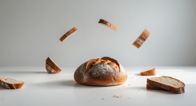 Loaf of Bread with Slices Suspended MidAir, a Culinary Still Life Scene, Studio Shot. photo