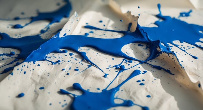 A blue paint splatter on a white surface photo