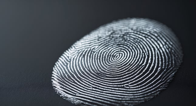 Fingerprint closeup on a dark surface, representing identification and individuality. photo