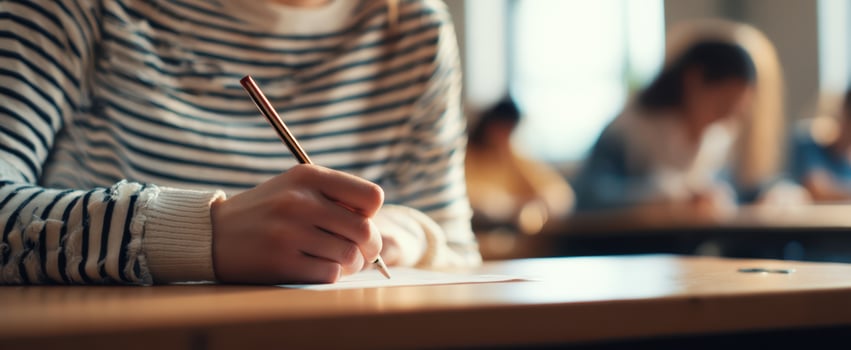 The student focusing on writing notes in a classroom environment. photo