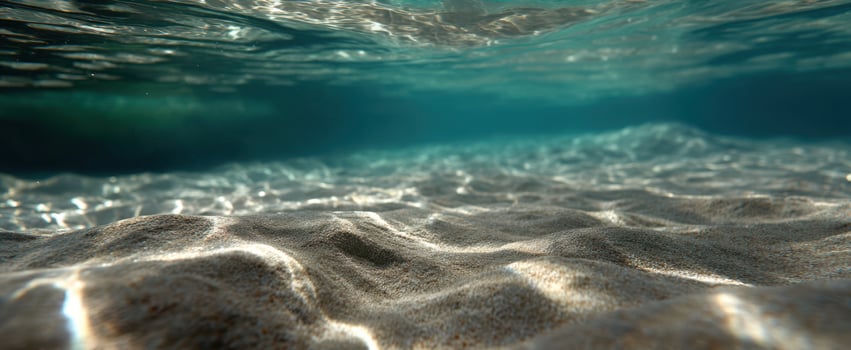 The serene underwater view of sparkling sand and gentle waves. photo