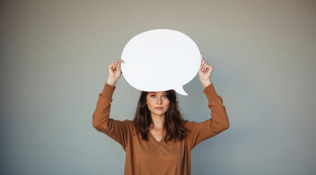 woman holds a white speech bubble over her head. photo