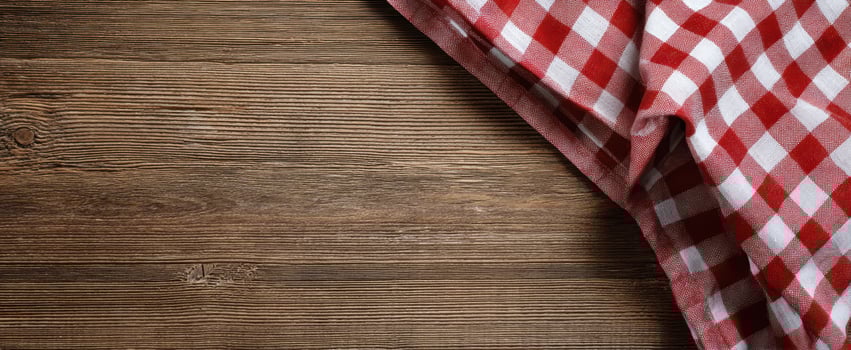 The checkered tablecloth adding charm to a rustic wooden surface. photo
