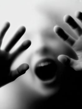 Frightened child reaching out with hands in a blurred background photo