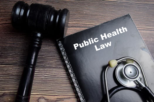 Concept of Public health law write on book with gavel and stethoscope isolated on Wooden Table. photo