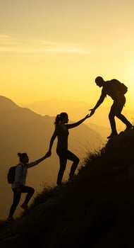 Three people helping each other up a mountain at sunset photo