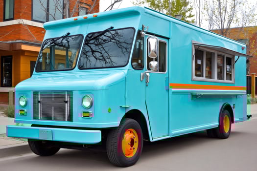 Turquoise food truck parked on a city street offering delicious meals photo