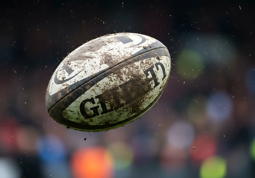 A rugby ball is seen in the air photo