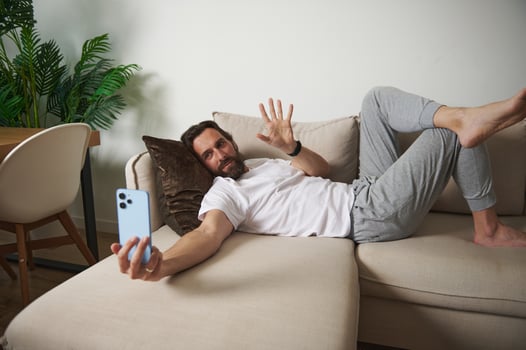 Casual Man Relaxing at Home While Interacting Through Call on Sofa photo