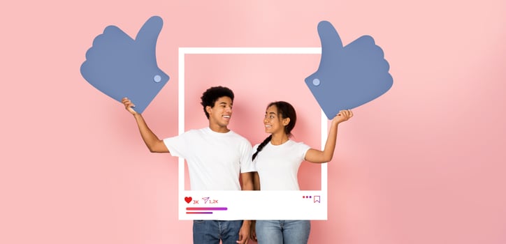 A young man and woman proudly display oversized thumbs up symbols, promoting social media interaction. photo