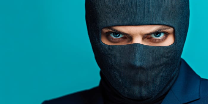 Mysterious figure in a black mask with piercing blue eyes against a vibrant turquoise background photo