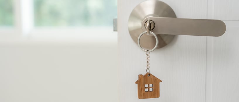 Moving house, relocation. The key was inserted into the door of the new house, inside the room was a cardboard box containing personal belongings and furniture, move in the apartment photo