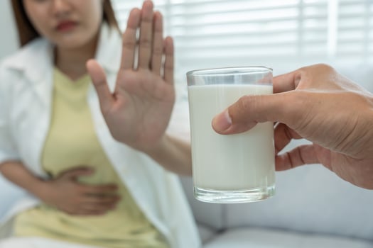 Milk allergen, woman confused milk, runny stuffy sore nose suffer from intolerance allergy trigger symptoms. abdominal pain, allergens, nut protein, rash, death, food allergy photo