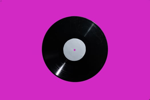 A stunning vintage vinyl record displayed against a bright pink background that captivates photo