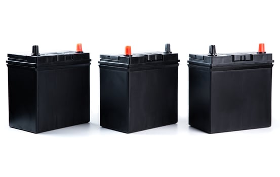 Row of three matching automotive batteries isolated on white background. Standard car power units for catalog listing, garage, or online store. photo