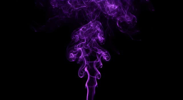 Mystical purple smoke plume creates an ethereal dance against black backdrop photo