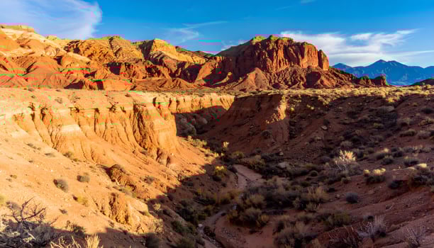 Majestic canyon landscape with deep valleys and layered red rock formations under bright sunlight photo