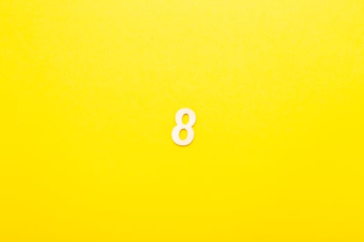 Top view of wooden number 8 eight on yellow bright background. photo
