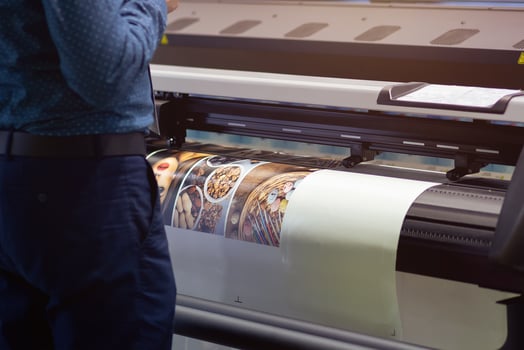 Industrial printing machine prints colorful poster in factory photo