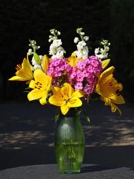 Romantic bouquet of vibrant garden flowers arranged in a glass vase photo