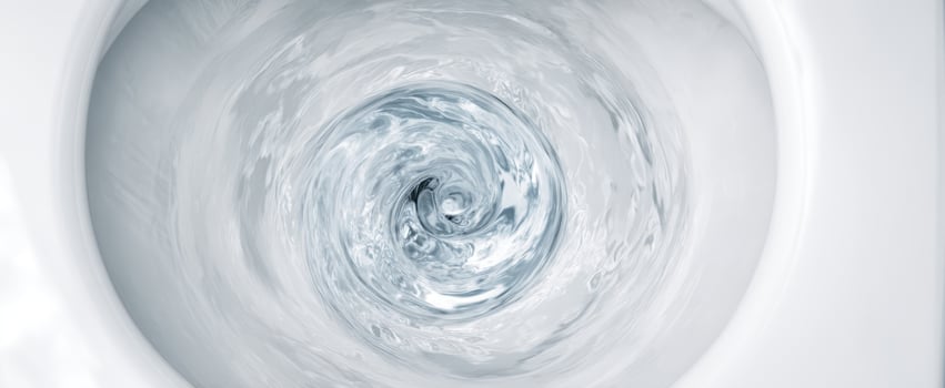 The swirling water inside a modern toilet bowl creating dynamic motion photo