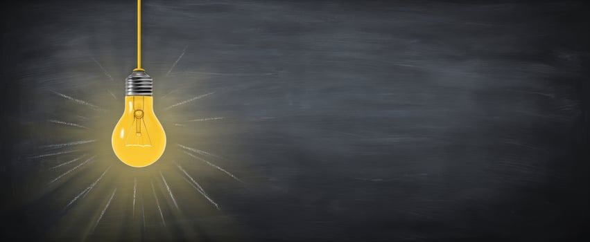 The illuminated yellow bulb hanging against a chalkboard background. photo