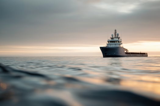 Gray Cargo Ship at Sunrise on Calm Ocean photo