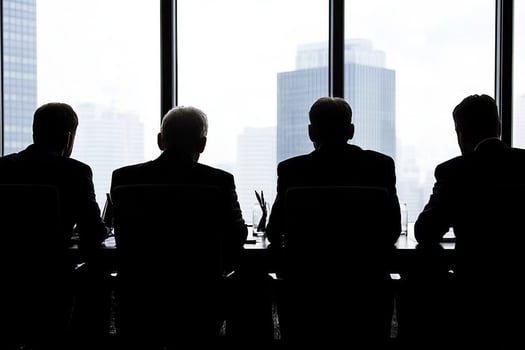 Silhouette of business people sitting at a table in front of a window photo