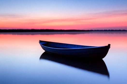 A boat is sitting on the water at sunset photo