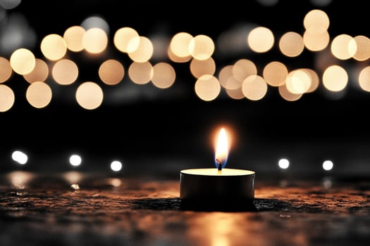 A candle is lit in front of a group of lights photo