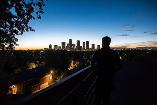 A man stands on a balcony overlooking the city skyline photo