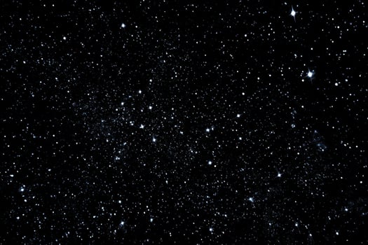 A black sky with stars and some small white dots photo