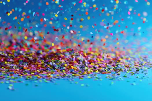 Colorful confetti falling on a blue background photo