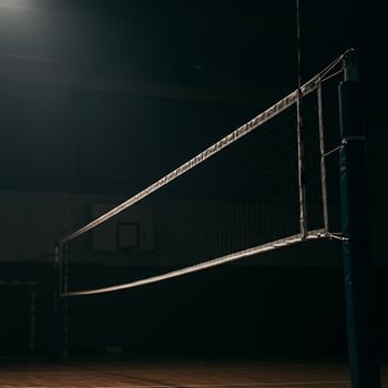 A volleyball net sits in the middle of a gym photo