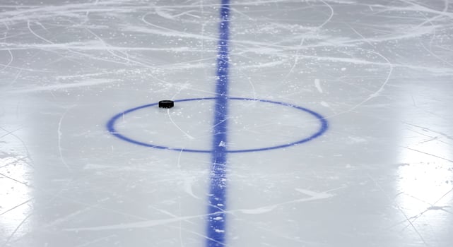 An ice hockey rink with a puck on the ice photo
